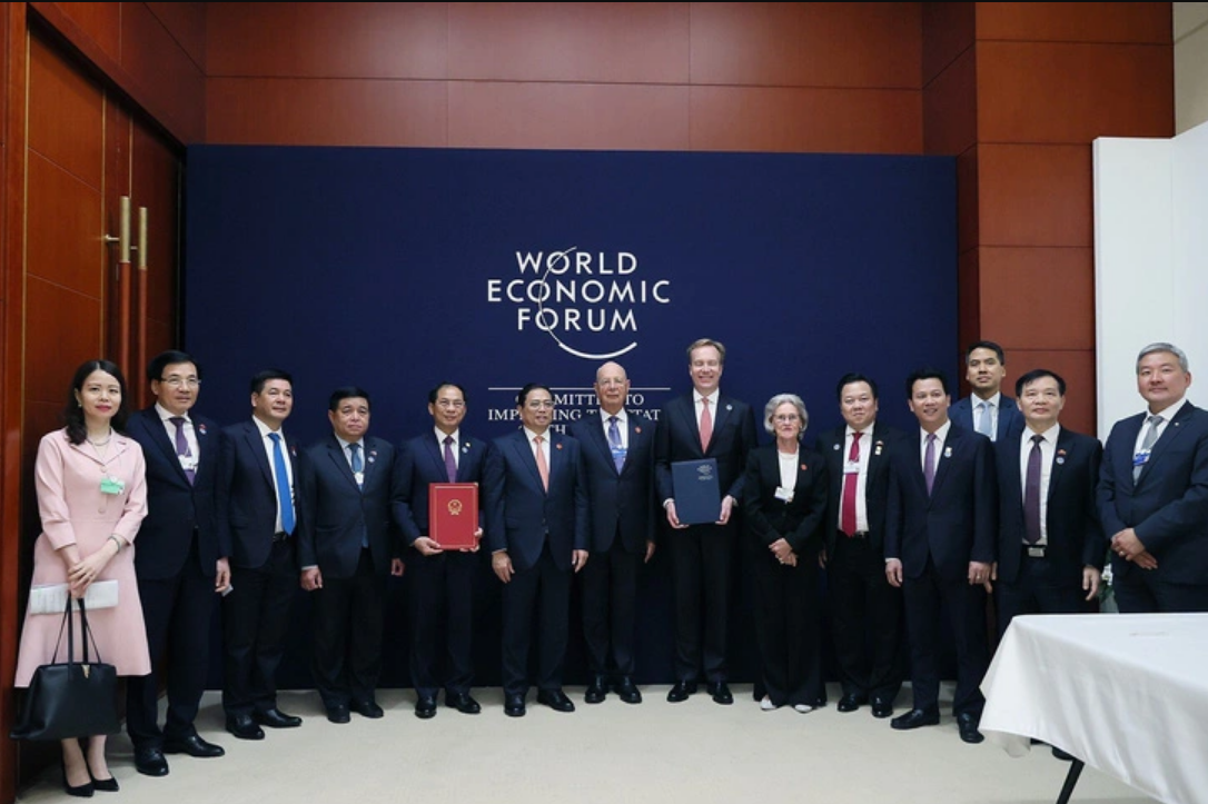 Prime Minister Pham Minh Chinh (6th, L) witnesses the signing of a memorandum of understanding with the WEF. Photo: Duong Giang / Tuoi Tre