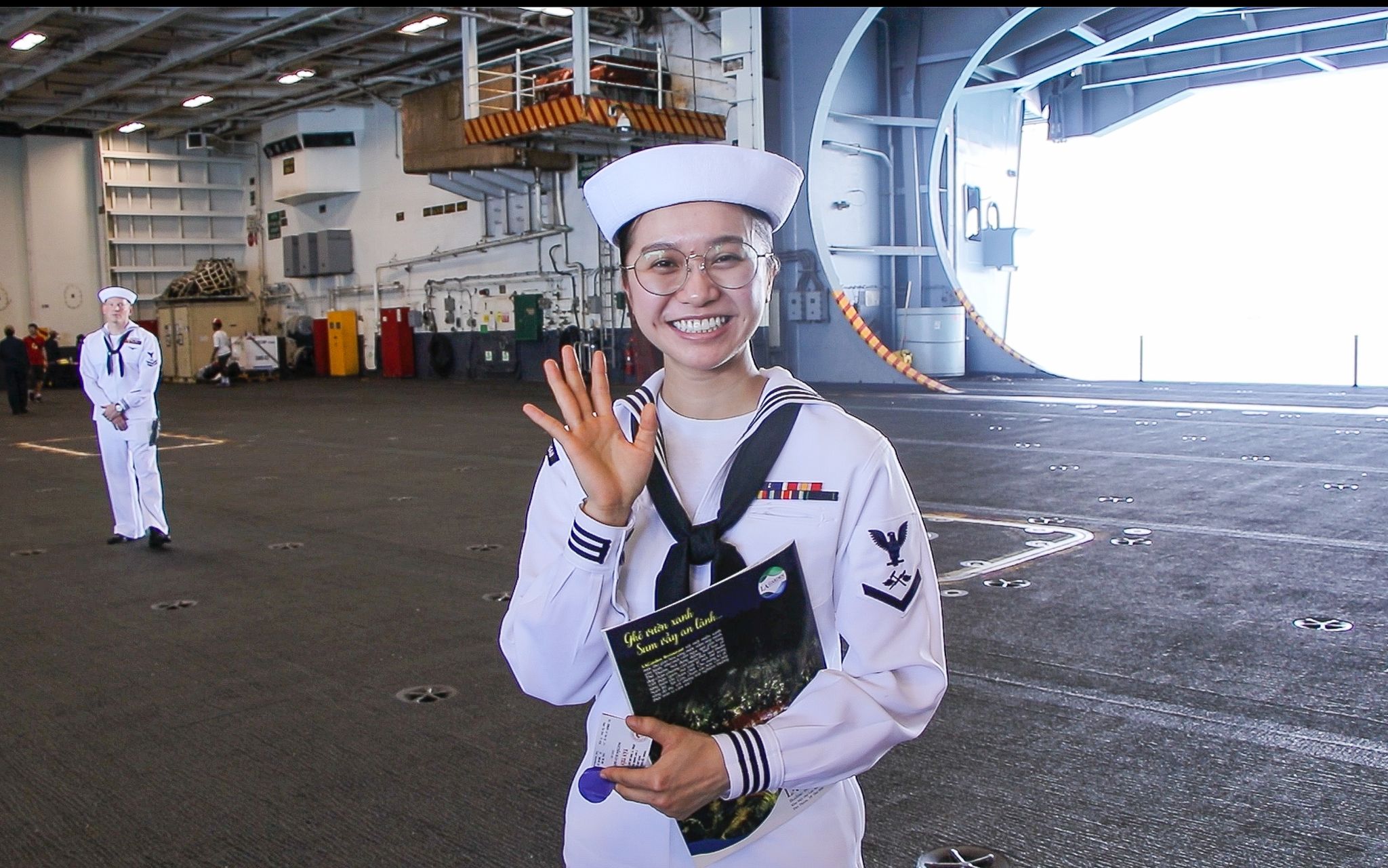 Doan Nhat Huyen Tran attracts the attention of visitors as she always smiles during their visit to USS Ronald Reagan. Photo: Duy Linh / Tuoi Tre