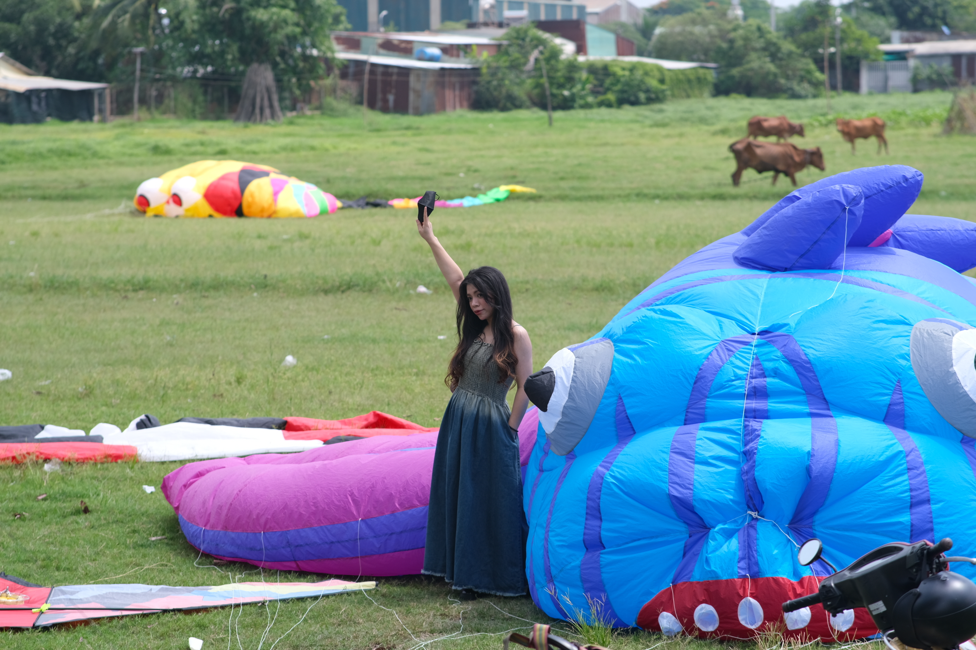 A woman poses for a photo with a giant kite on a field in Hoc Mon District, Ho Chi Minh City. Photo: Ngoc Phuong / Tuoi Tre News