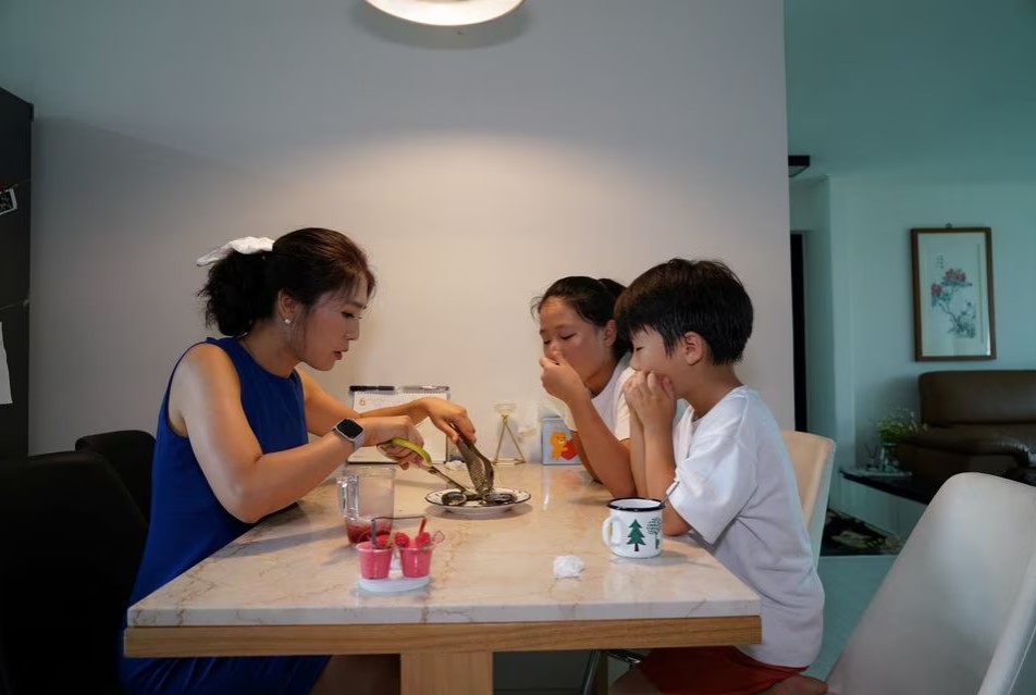 Lee Young-Min, 38, has a seafood meal with her children at her house in Seongnam, South Korea, June 28, 2023. Photo: Reuters