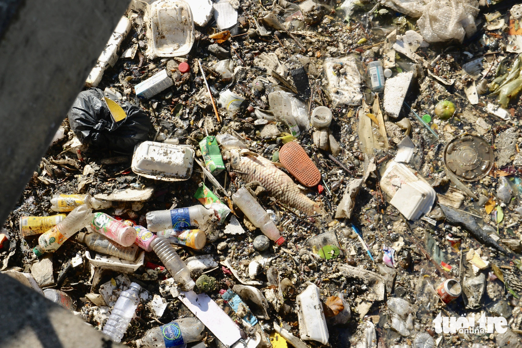 A large volume of trash blankets another canal surface section