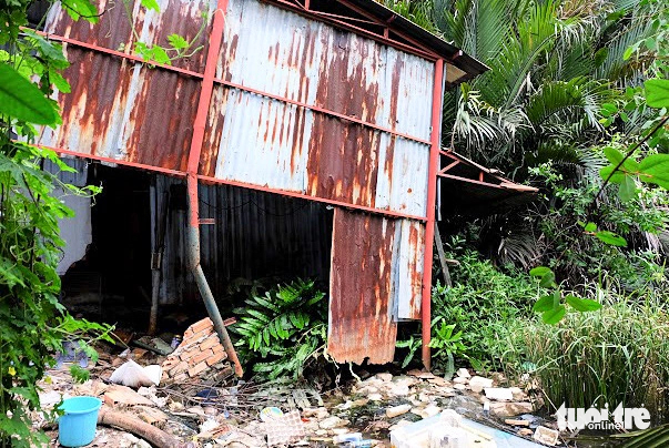 A riverside house is damaged by land erosion facing Phuoc Loc Bridge in the outlying district of Nha Be. Photo: Phuong Nhi / Tuoi Tre