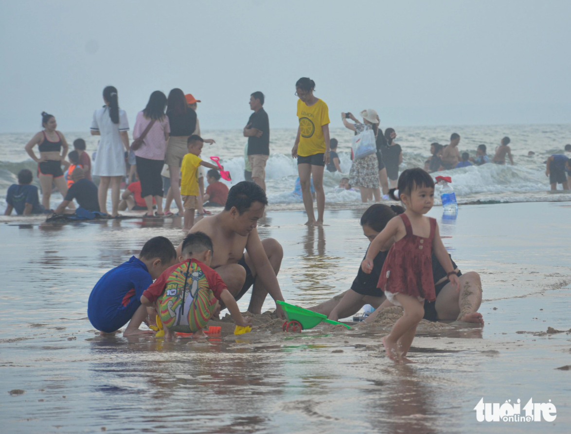 Visitors are pictured playing on a beach in Phan Thiet City. Photo: Duc Trong / Tuoi Tre