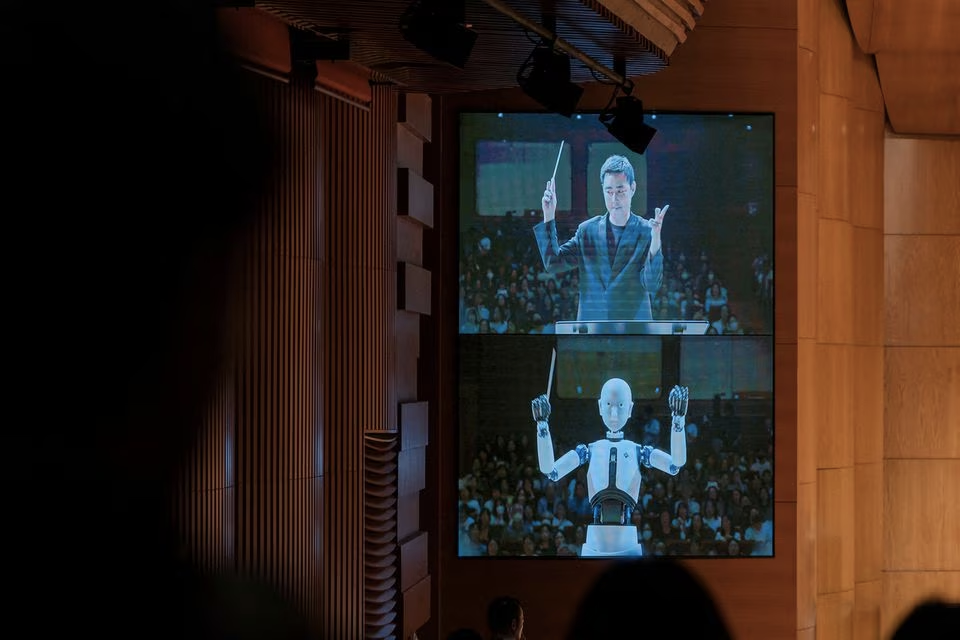 An android robot, EveR 6, is seen on a screen as it takes the conductor's podium to lead a performance by South Korea's national orchestra with human conductor Choi Soo-yeoul, in Seoul, South Korea, June 30, 2023, in this handout picture. National Theater of Korea/Handout via Reuters