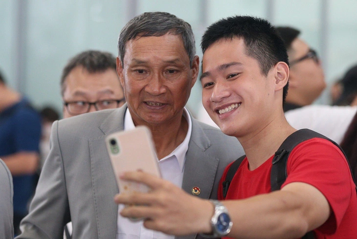 Head coach Mai Duc Chung (L) poses for a photo with a fan at Noi Bai International Airport in Hanoi before the departure for New Zealand to begin Vietnam’s participation in the 2023 FIFA Women’s World Cup, July 5, 2023. Photo: Duc Khue / Tuoi Tre