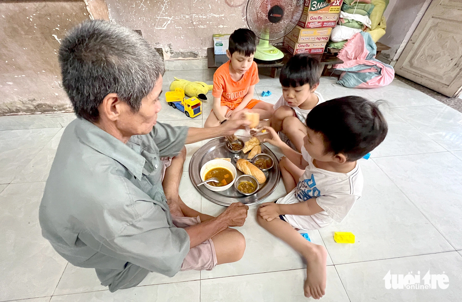 Ngo Quang Dang and his three sons have a meal provided by a kind-hearted person. Photo: Yen Trinh / Tuoi Tre