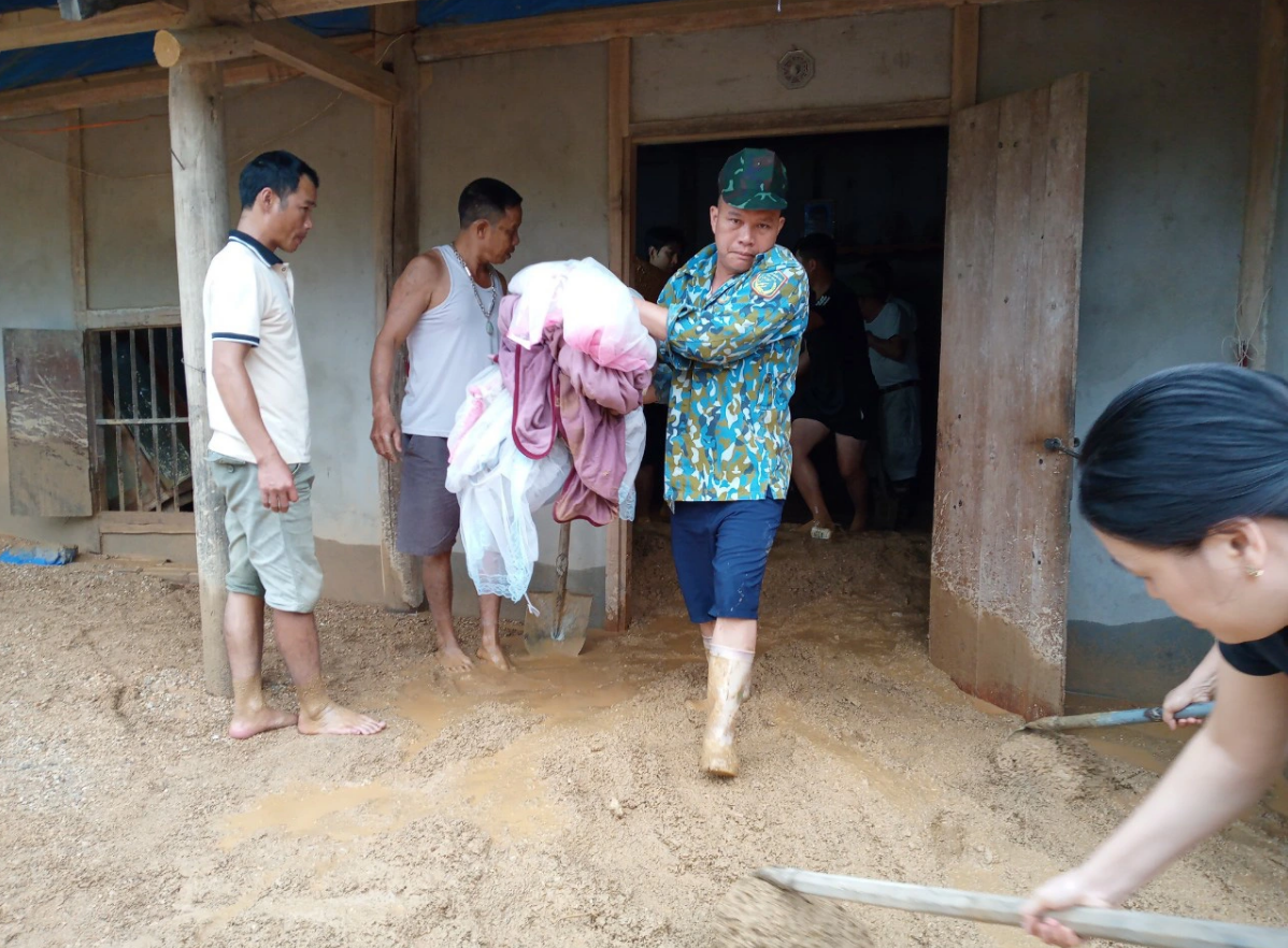 Residents clean a house and clear away mud after floods triggered by heavy rains. Photo: C. Nhan / Tuoi Tre