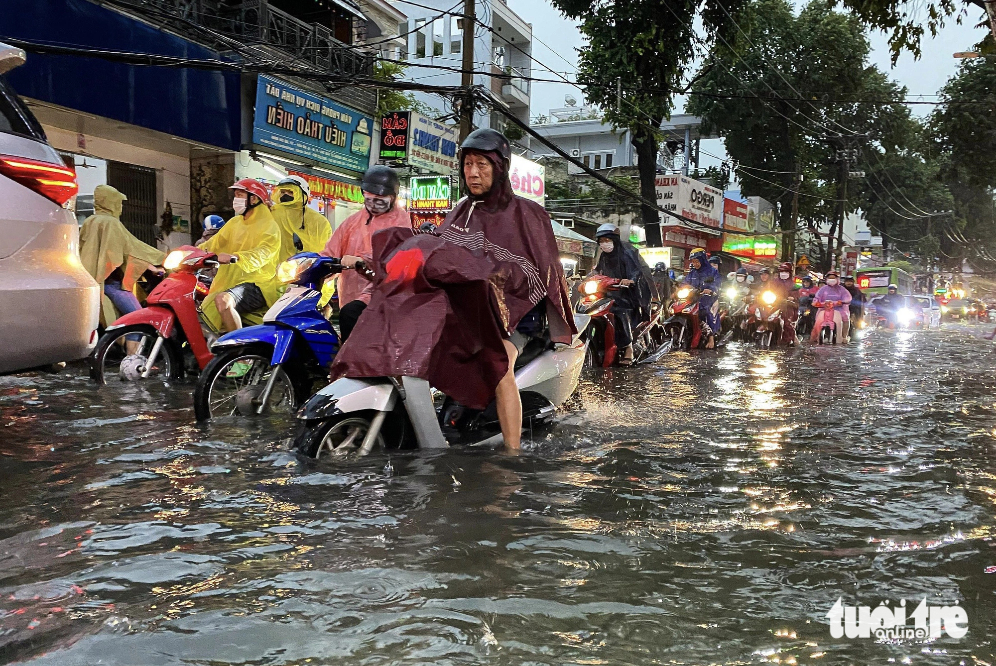 Motorcyclists ride through a severely flooded street in Ho Chi Minh City on July 5, 2023. Photo: Xuan Mai / Tuoi Tre