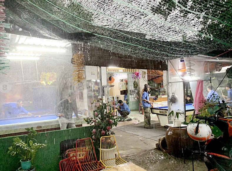 Quang, owner of a coffee and billiards shop, said that he must cover his shop with nylon sheets to prevent dust and noise when garbage trucks travel to the Da Phuoc area in Binh Chanh District. Photo: T.T.D. / Tuoi Tre