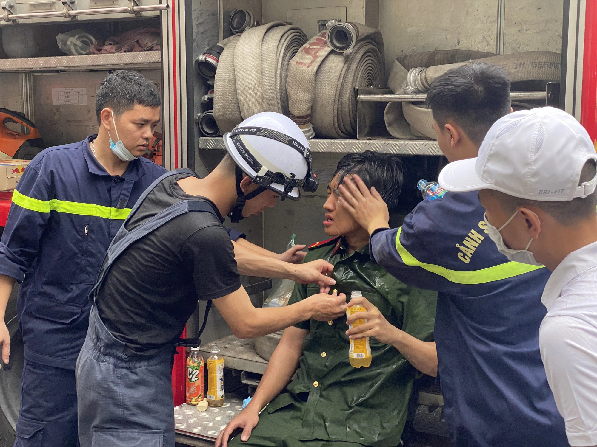 A police officer is seen exhausted after joining the fire-fighting and rescue operation. Photo: Chi Tue / Tuoi Tre