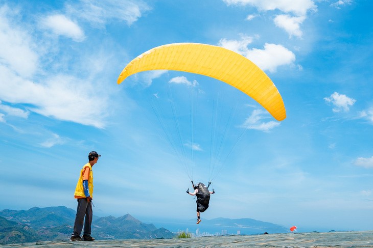 A tourist takes off for paragliding in Hon En Mountain, Nha Trang City, Khanh Hoa Province. Photo: Do Phuong / Tuoi Tre