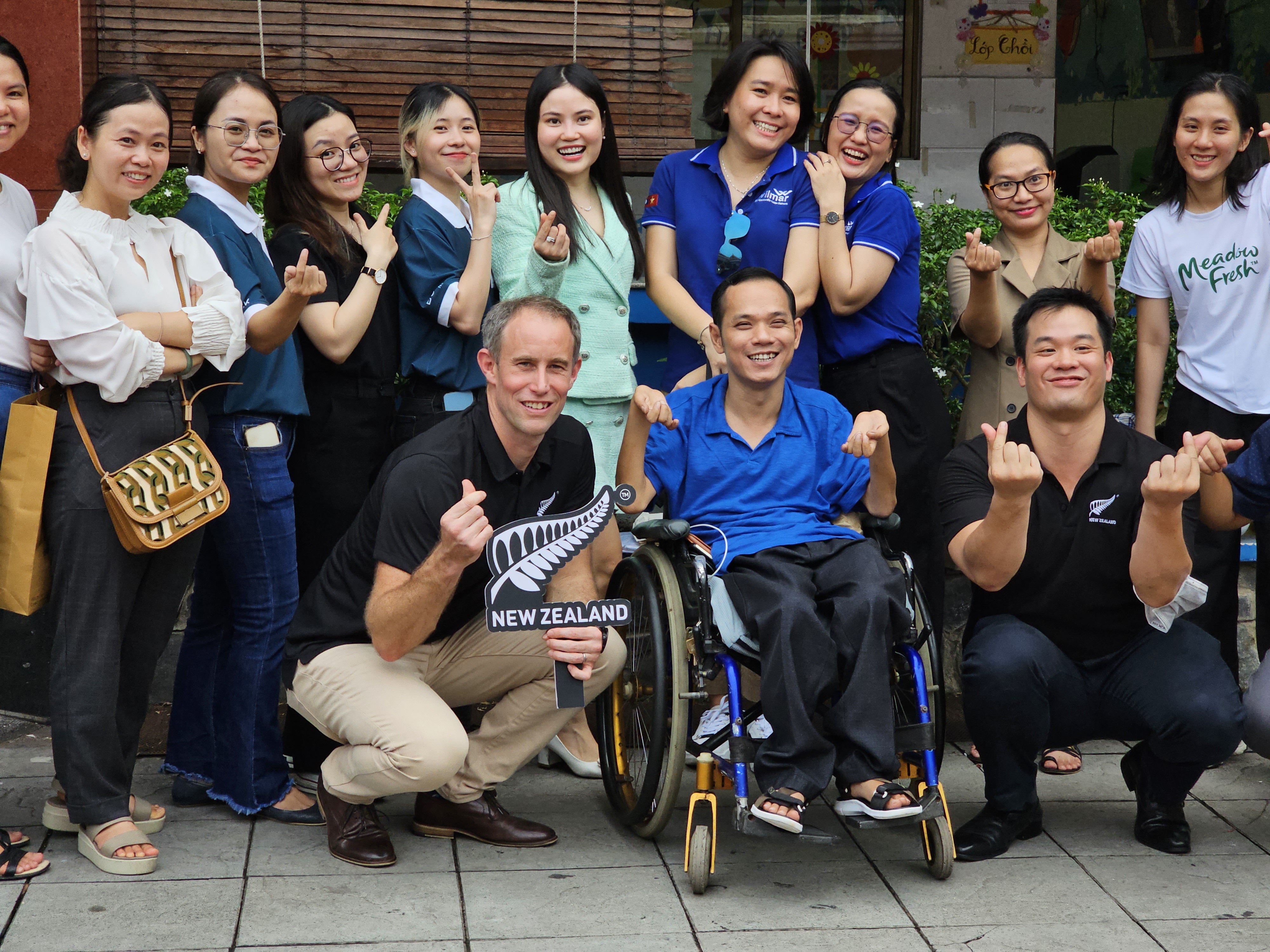 Scott James takes photos with employees of Maison Chance and the donators. Photo: Ngoc Duc / Tuoi Tre