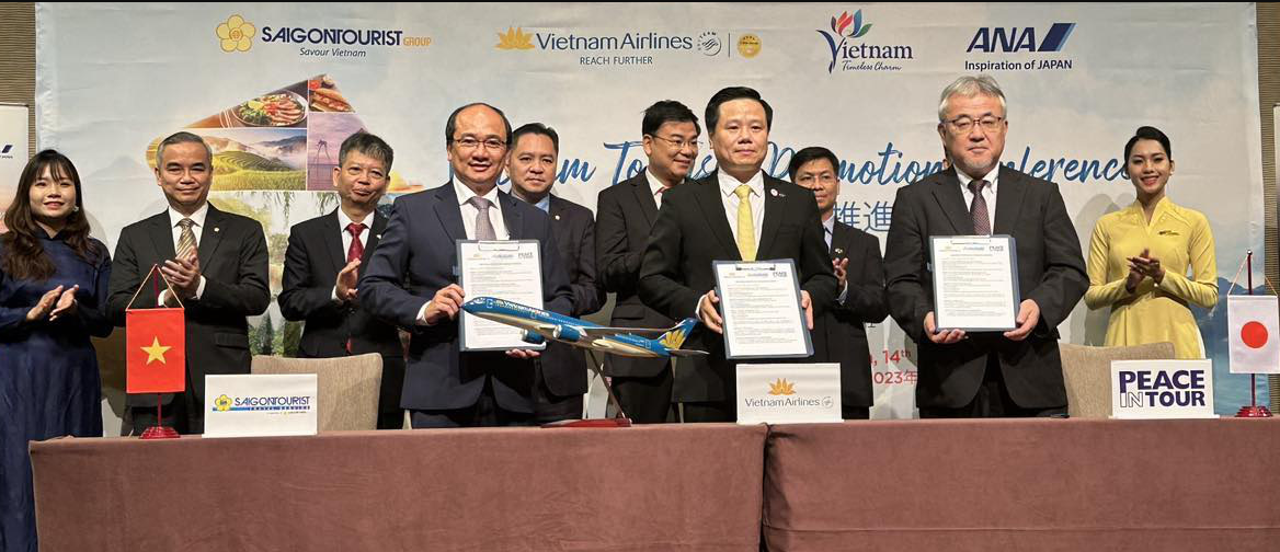 Representatives of Saigontourist Travel Service Company, Vietnam Airlines and Peace In Tour sign cooperation agreements at the program. Photo: X.T. / Tuoi Tre