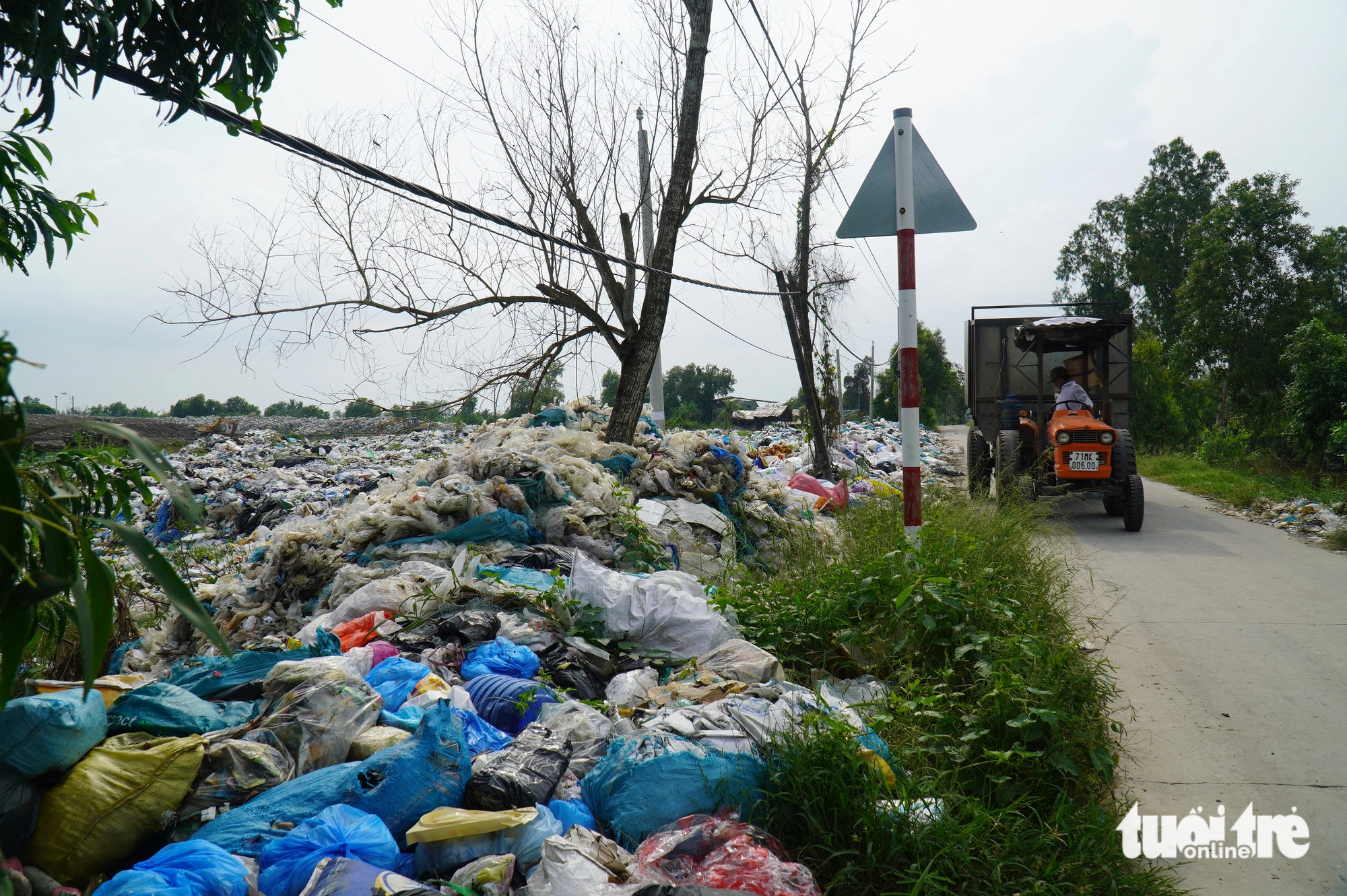 Garbage at the An Hiep landfill spreads to a nearby road. The landfill management unit has now built a fence surrounding the site. Photo: Mau Truong / Tuoi Tre
