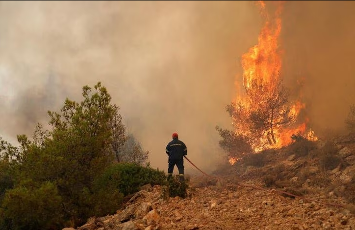 A firefighter tries to extinguish a wildfire burning near the village of Kandyli, near Athens, Greece, July 19, 2023. Photo: Reuters