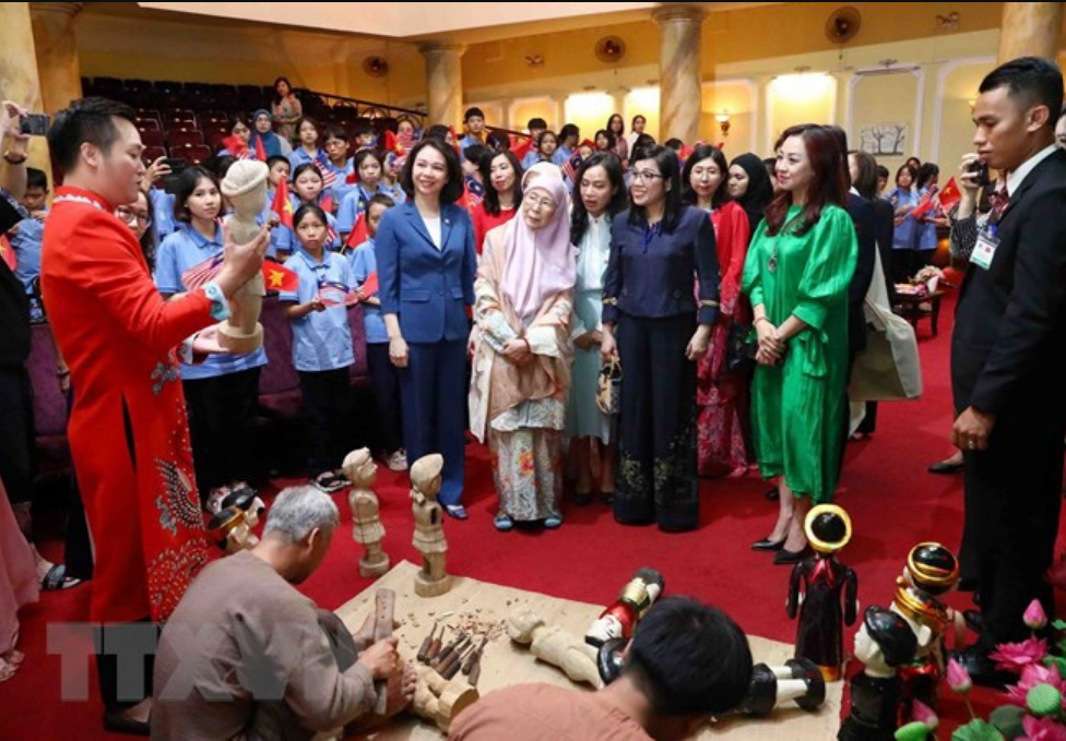 A representative of the Vietnam Contemporary Art Theater in Hanoi introduces water puppets and puppetry to the spouses of the Vietnamese and Malaysian prime ministers. Photo: Vietnam News Agency