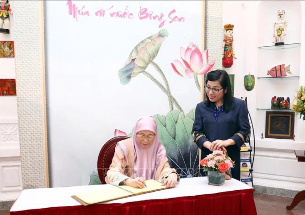 The Malaysian prime minister’s spouse Dato’ Seri Dr. Wan Azizah binti Dr. Wan Ismail writes on a book at the Vietnam Contemporary Art Theater in Hanoi. Photo: Vietnam News Agency