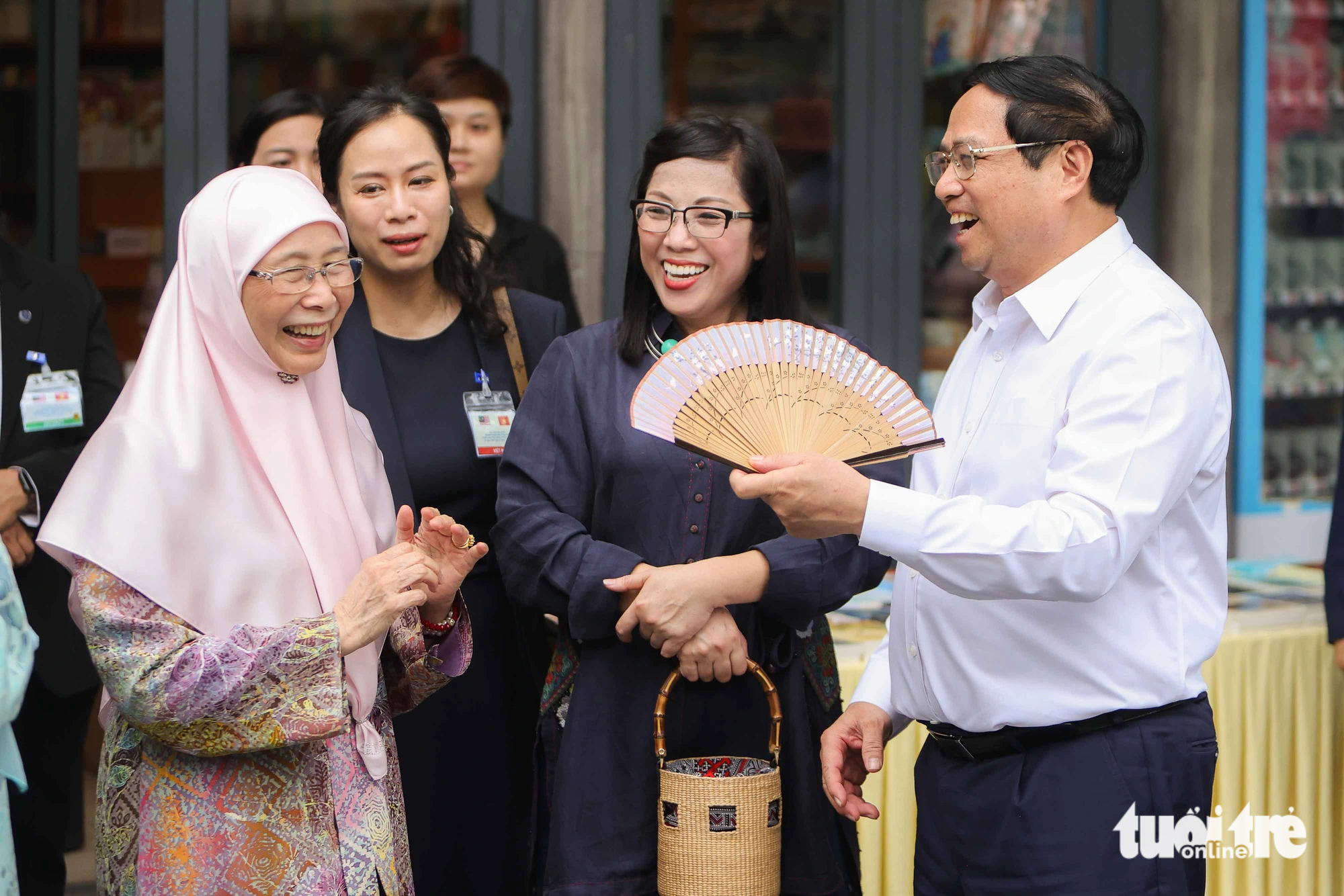 Malaysian Prime Minister Anwar Ibrahim’s spouse Dato' Seri Dr. Wan Azizah Binti Wan Ismail (L, 1st) laughed and thanked PM Chinh (R, 1st) for using a fan to cool down her and his spouse (R, 2nd). Photo: Nguyen Khanh / Tuoi Tre