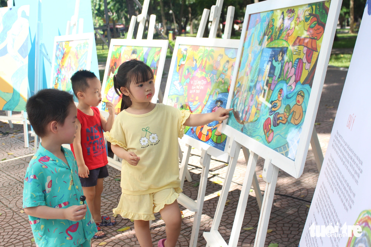 Kids are excited at some pictures highlighting drowning prevention on display at the event. Photo: Duong Lieu / Tuoi Tre