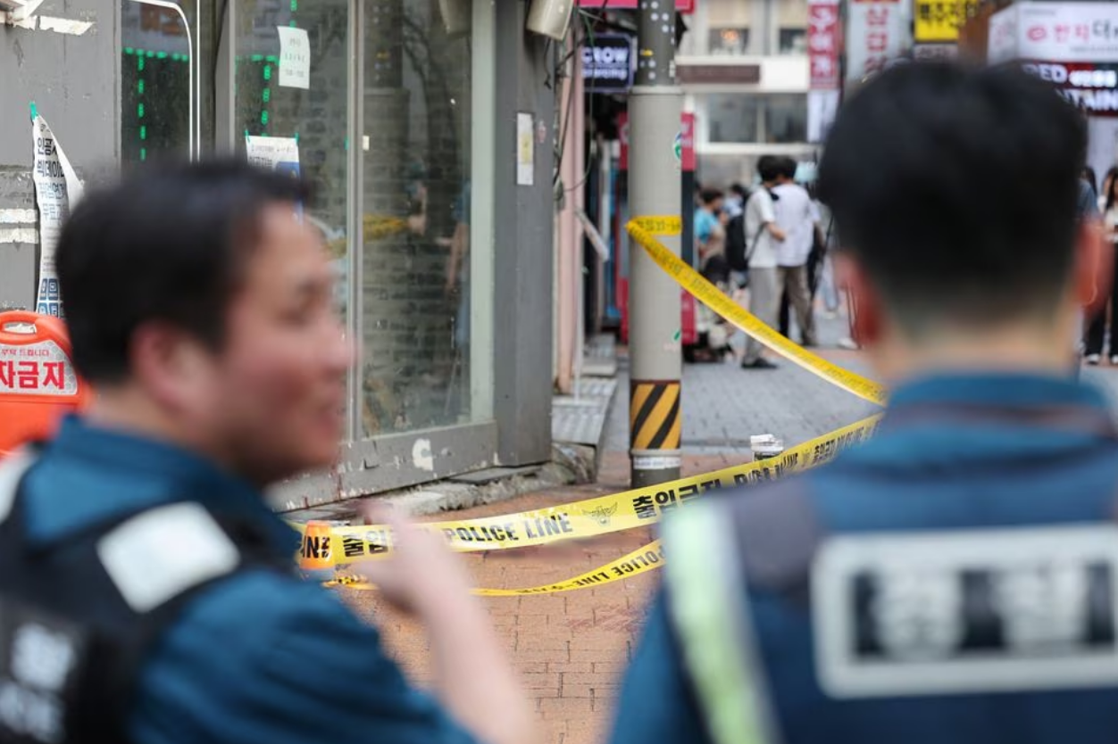 Policemen look at the scene of a stabbing attack by un identified man in his 30s in which one person was killed and three wounded near a subway station, in Seoul, South Korea, July 21, 2023. Photo: Reuters