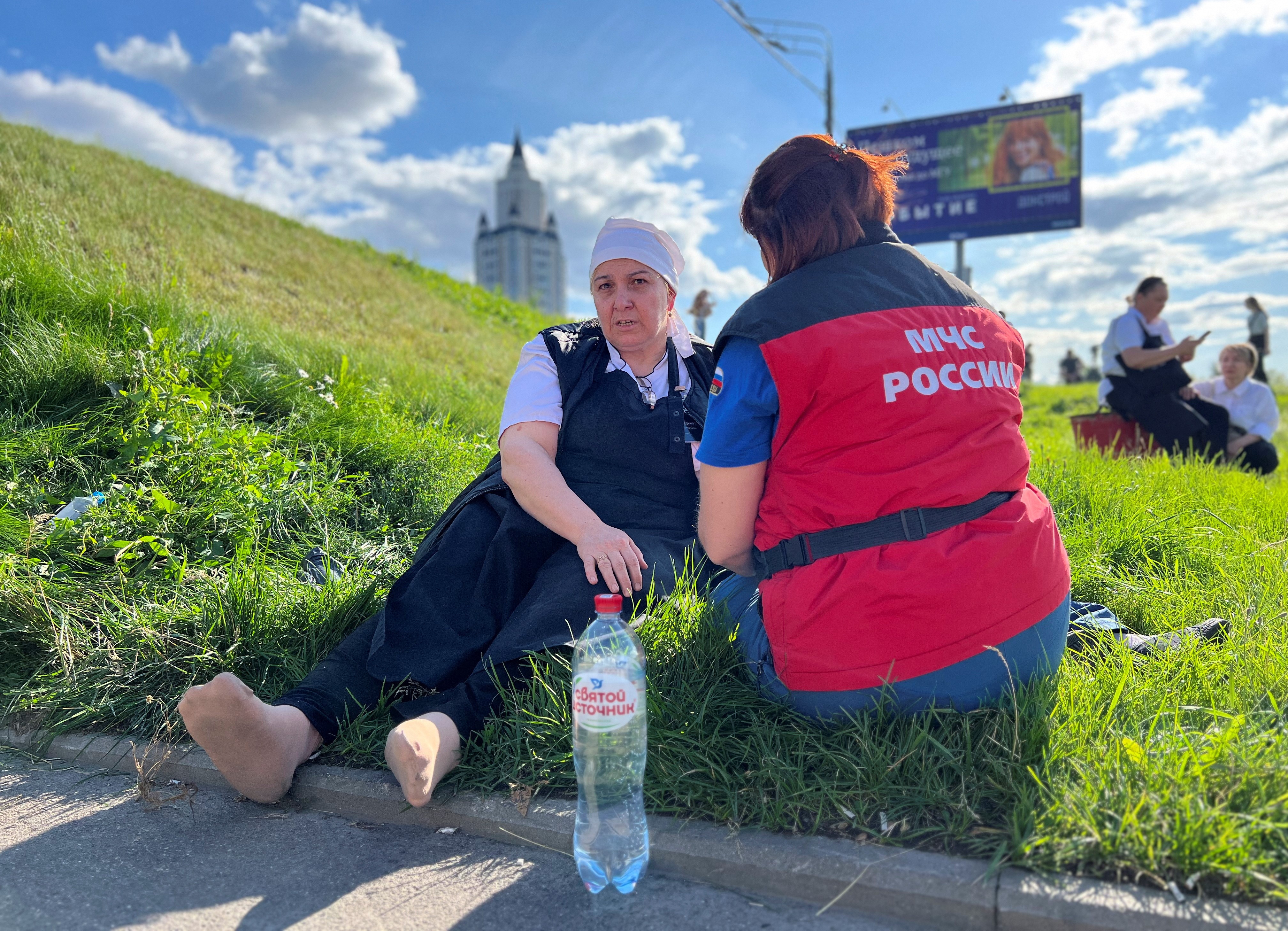 A member of the Russian emergencies ministry gives a woman medical treatment near the shopping mall Vremena Goda (The Seasons) following the burst of a pipe carrying boiling hot water in Moscow, Russia, July 22, 2023. Photo: Reuters