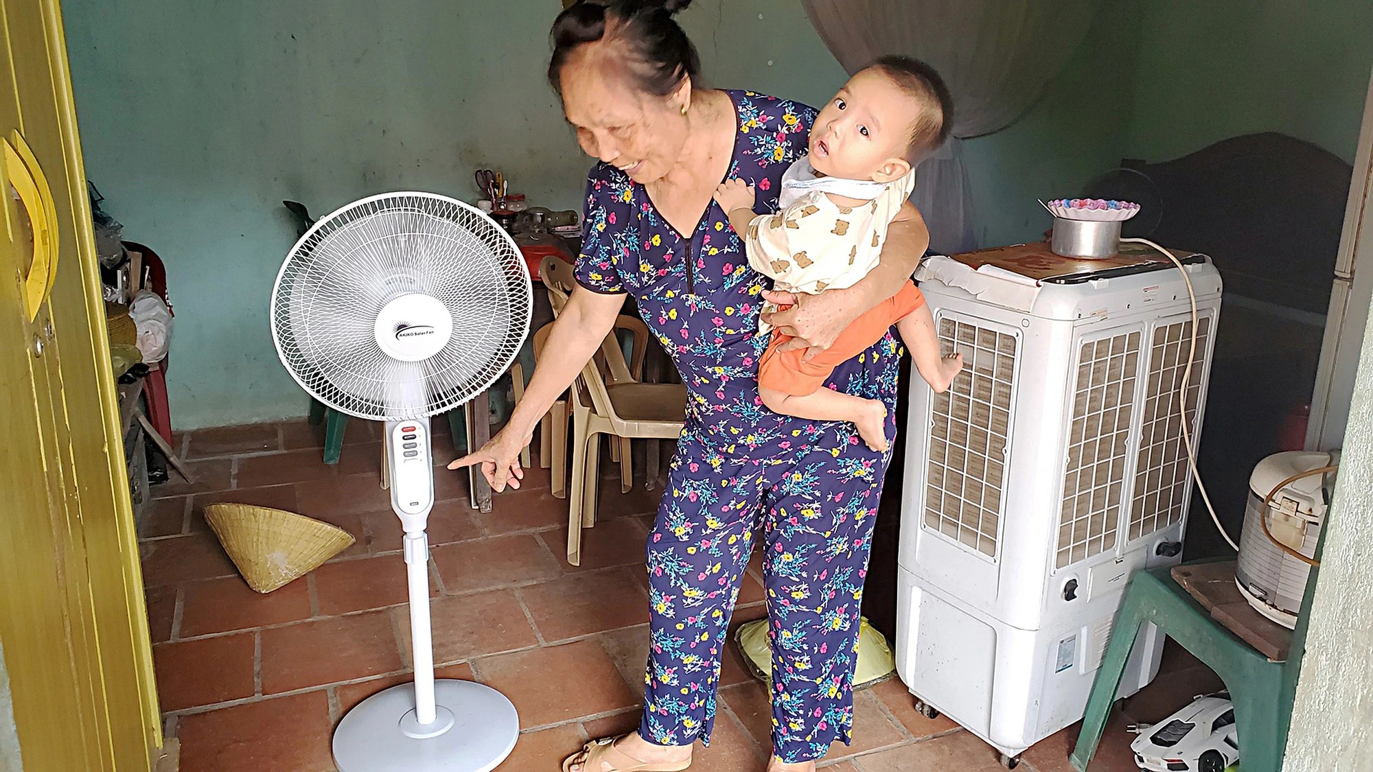 Nguyen Thi Quy turns on the electronic fan with energy from her family's solar panel system. Photo: Tam Le / Tuoi Tre