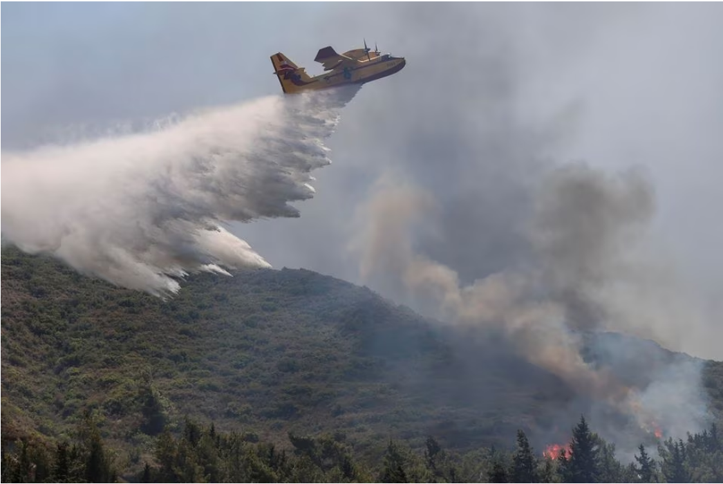 A firefighting plane makes a water drop on the island of Rhodes, July 25, 2023. Photo: Reuters