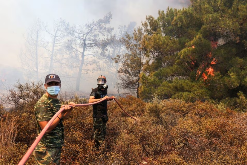 Volunteers try to tackle a wildfire burning near the village of Vati on the island of Rhodes, July 25, 2023. Photo: Reuters