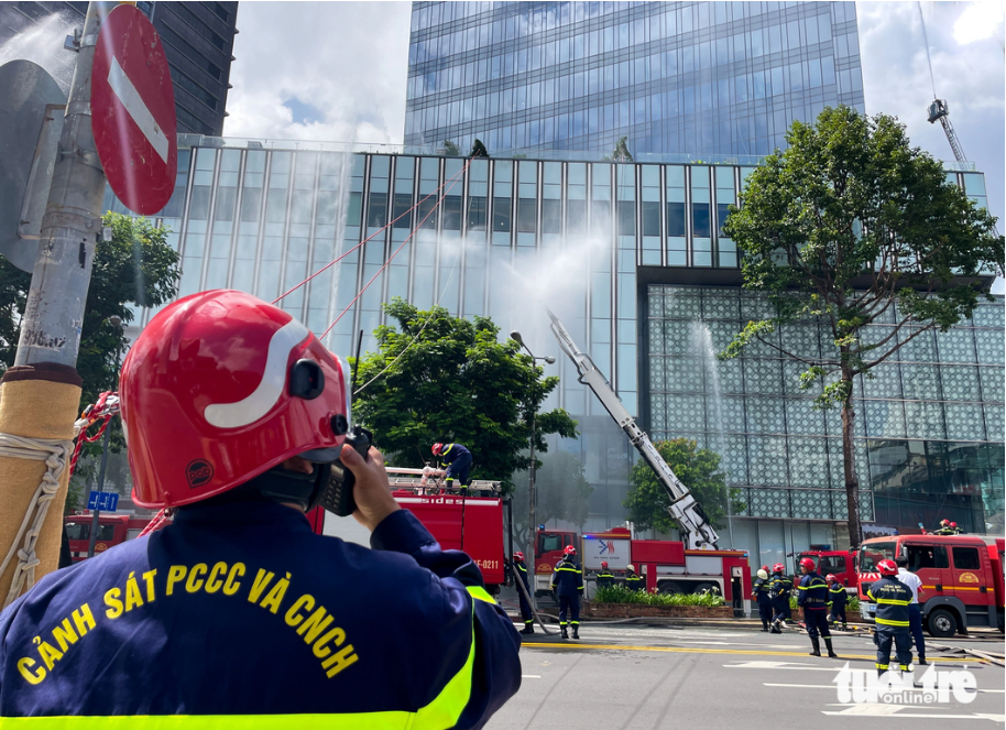 The head of the firefighting force at Saigon Centre in  District 1, Ho Chi Minh City regulate the fire fighting through a walkie-talkie.