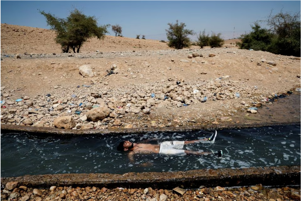 A Palestinian man cools off during a heatwave in the al-Oja Springs near Jericho in the Israeli-occupied West Bank, July 18, 2023. Photo: Reuters