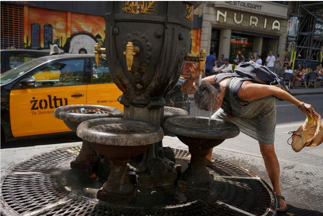 A tourist cools herself in a fountain amid a heatwave at Las Ramblas in Barcelona, Spain, July 19, 2023. Photo: Reuters
