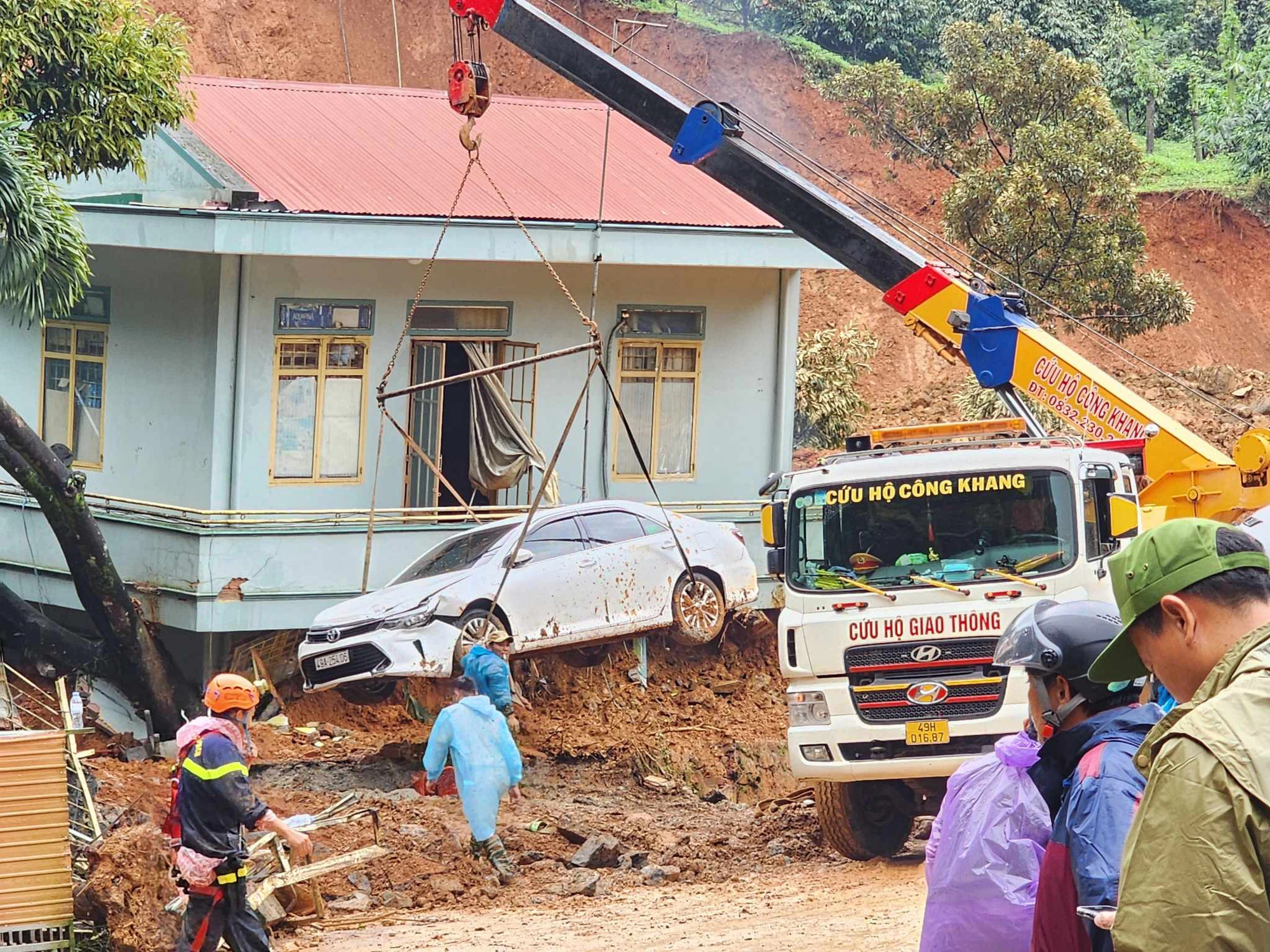 A rescue truck pulls out one of the two cars being buried in the fatal landslide, July 30, 2023. Photo: Son Dinh / Tuoi Tre