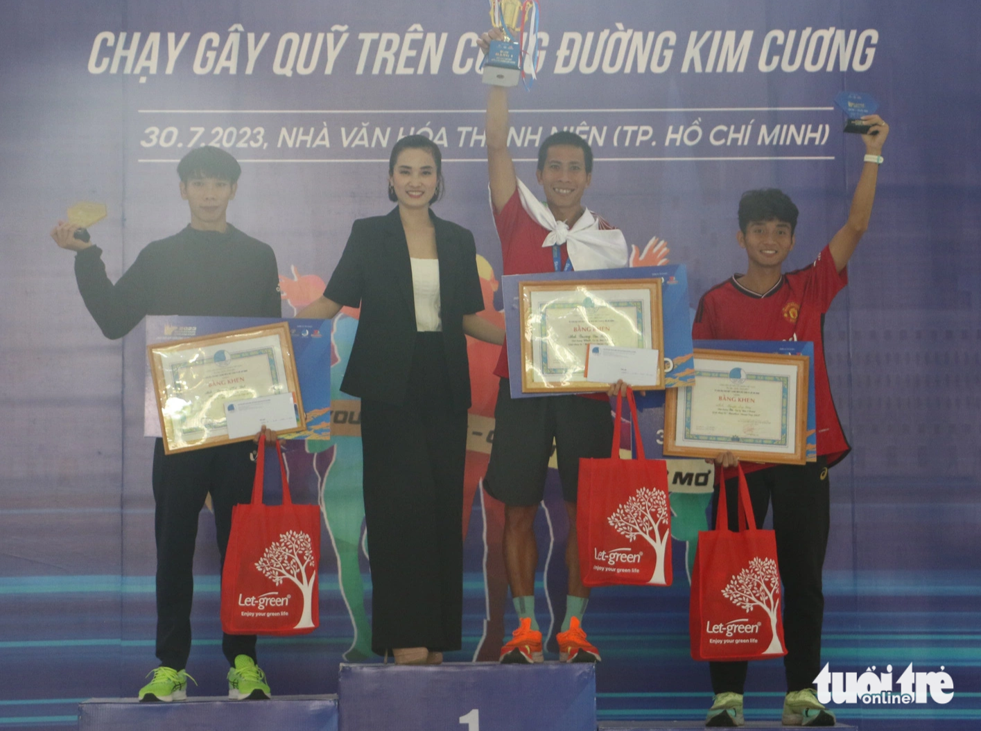 The three winners of the men’s 5km race are awarded first, runner-up, and second runner-up prizes at the 2023 Marathon Dream Cup in Ho Chi Minh City, July 30, 2023. Photo: Binh Minh / Tuoi Tre