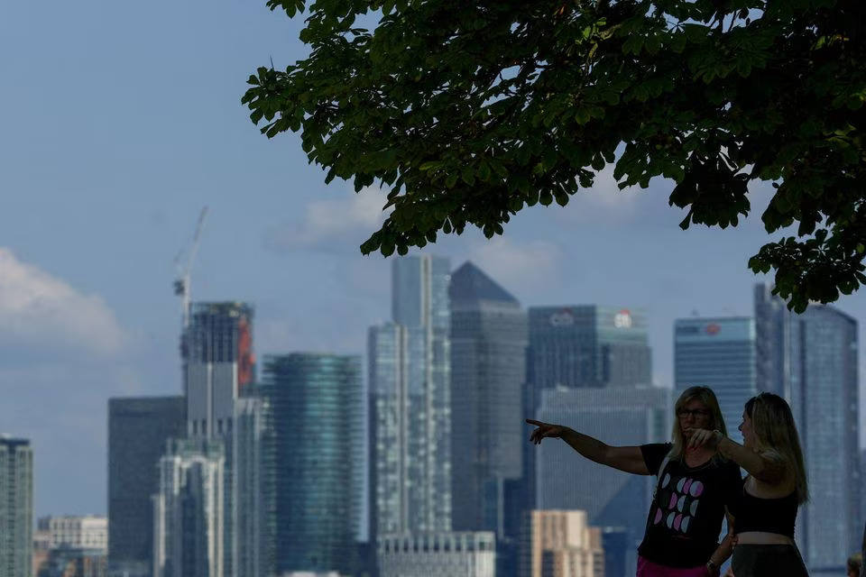 People look out from Greenwich Park, with Canary Wharf in the distance, in London, Britain June 22, 2023. Photo: Reuters