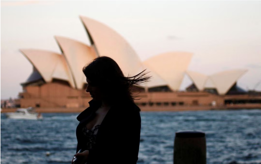 An office worker walks past the Sydney Opera House as she leaves Sydney's CBD September 26, 2012. Photo: Reuters