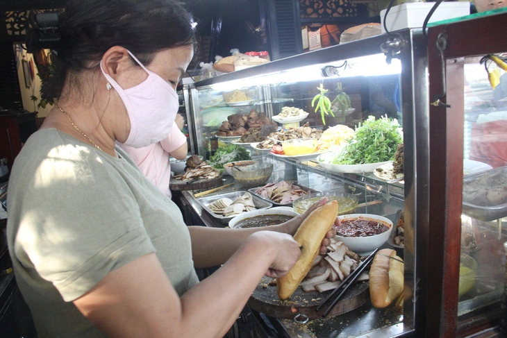 Staff make banh mi at Banh Mi Phuong shop in Hoi An City, Vietnam. Photo: Truong Trung / Tuoi Tre