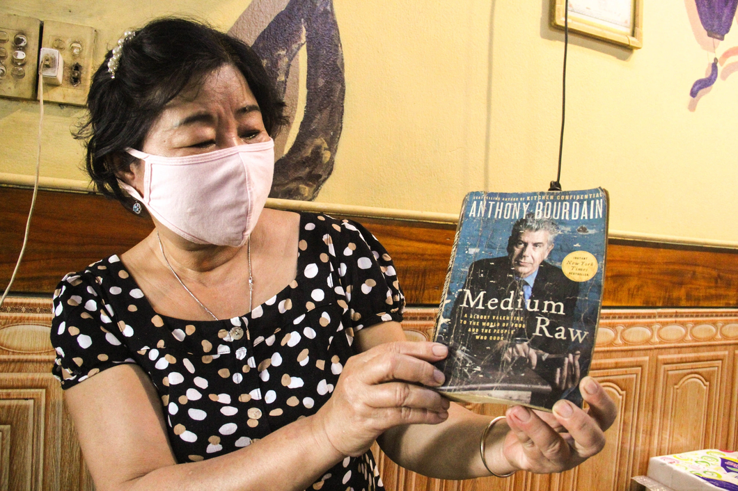 Truong Thi Phuong, owner of Banh Mi Phuong in Hoi An City, holds a book she was gifted by Anthony Bourdain. Photo: Truong Trung / Tuoi Tre