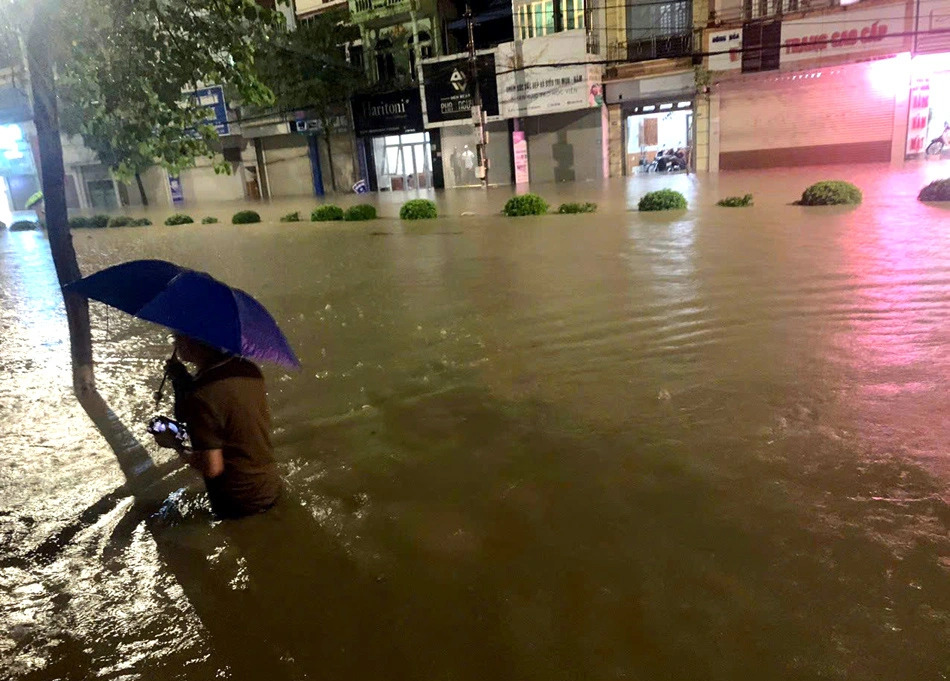 A resident wades through waist-high floodwaters on Vo Nguyen Giap Street, Dien Bien Phu City, Dien Bien Province, northern Vietnam, August 2, 2023. Photo: Thu Hang / Tuoi Tre