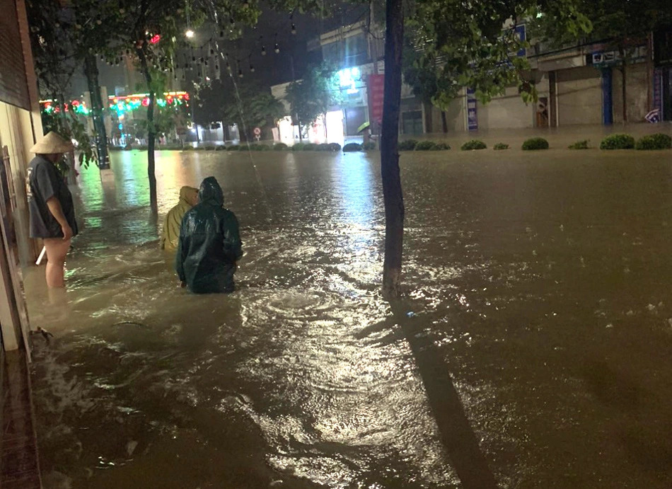 Residents wade through waist-high floodwaters on Vo Nguyen Giap Street, Dien Bien Phu City, Dien Bien Province, northern Vietnam, August 2, 2023. Photo: Thu Hang / Tuoi Tre