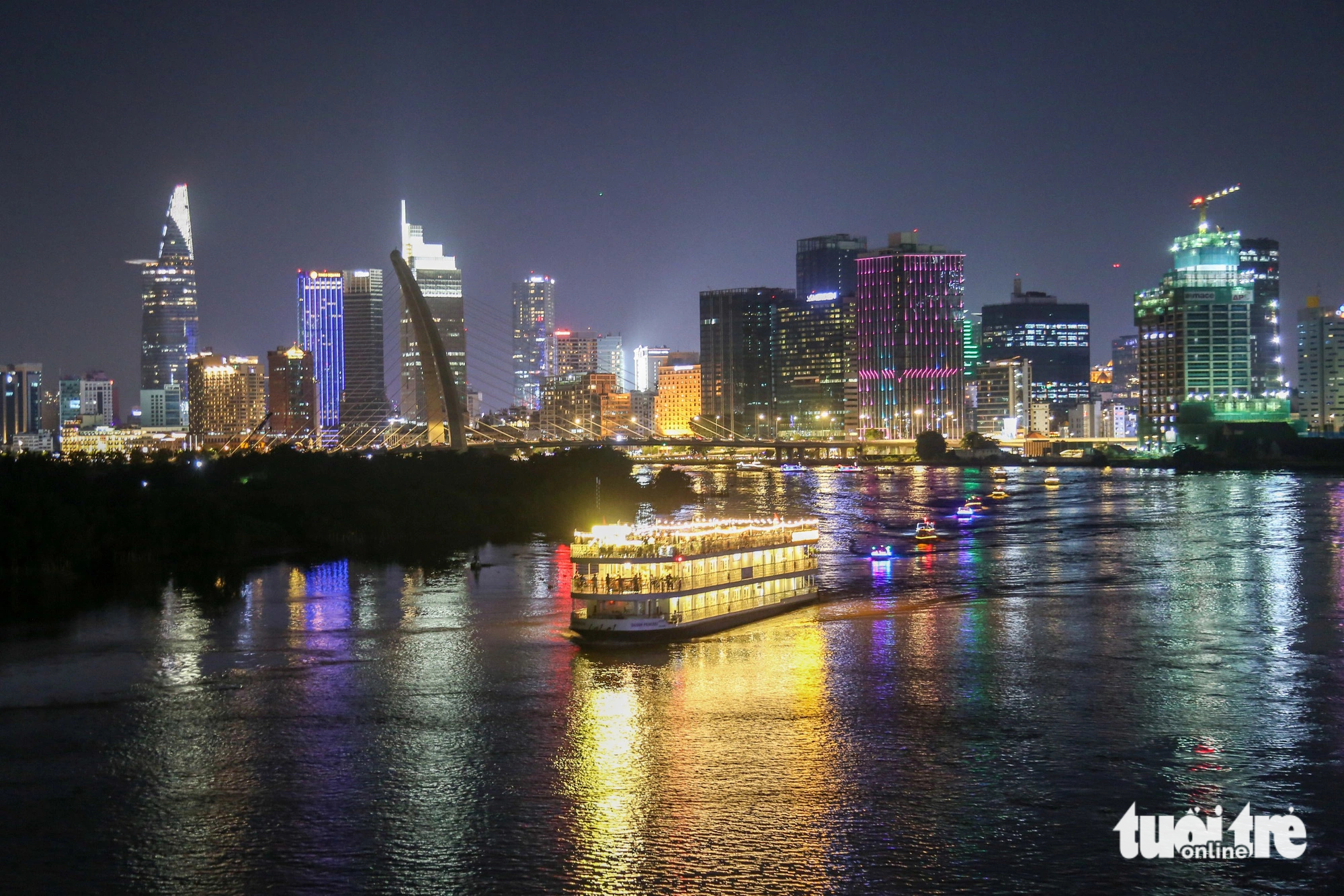 Illuminated boats are on parade near the Ba Son Bridge, which spans over the Saigon River and links District 1 with Thu Duc City in Ho Chi Minh City. Photo: Phuong Quyen / Tuoi Tre