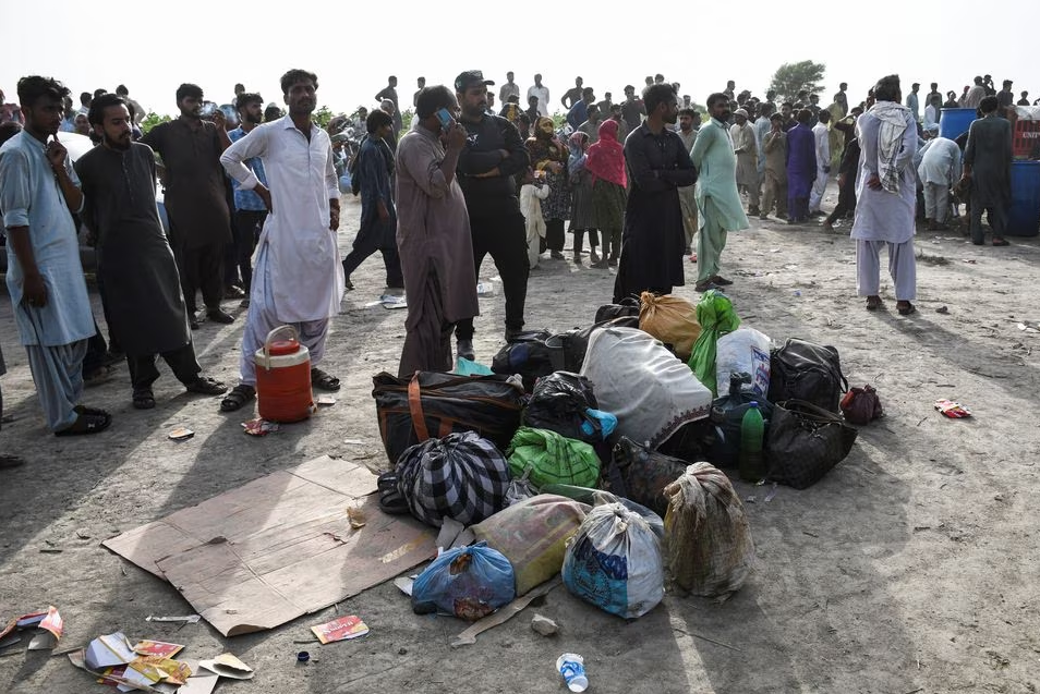 People with belongings stand at the site after a train derailed in Sarhari town in district Sanghar, Pakistan August 6, 2023. Photo: Reuters