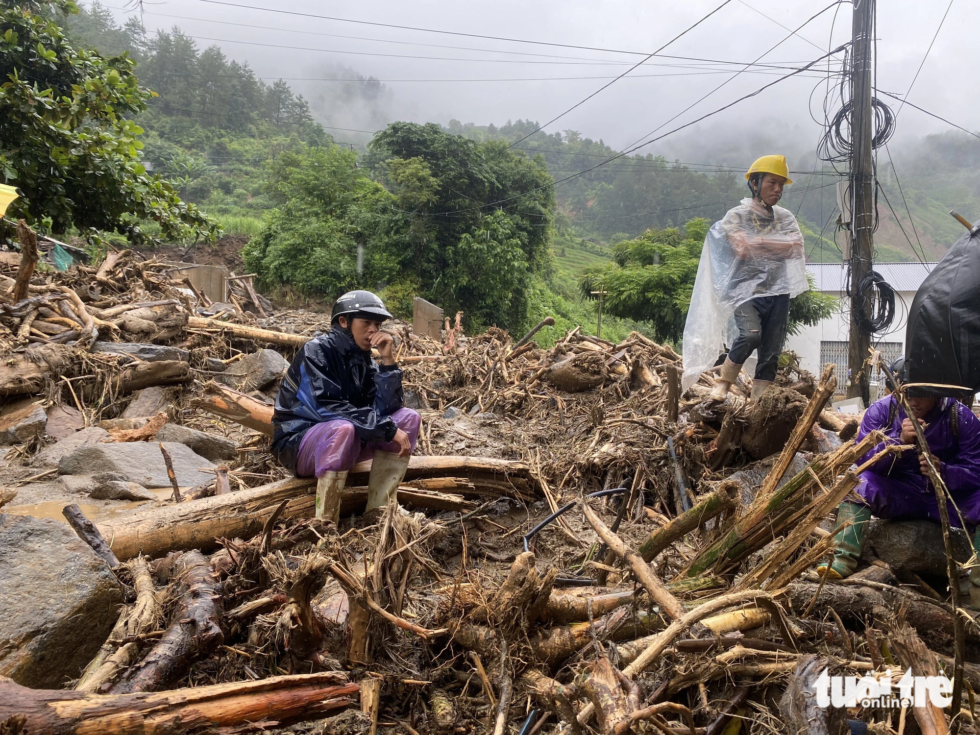 A local man sits on a fallen branch after his house was swept away by floodwaters. Photo: Chi Tue / Tuoi Tre