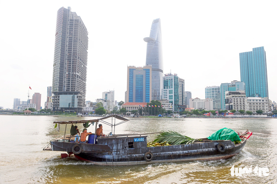 A photo of a boat passing by skyscrapers is taken from a water bus. Photo: Quang Dinh / Tuoi Tre