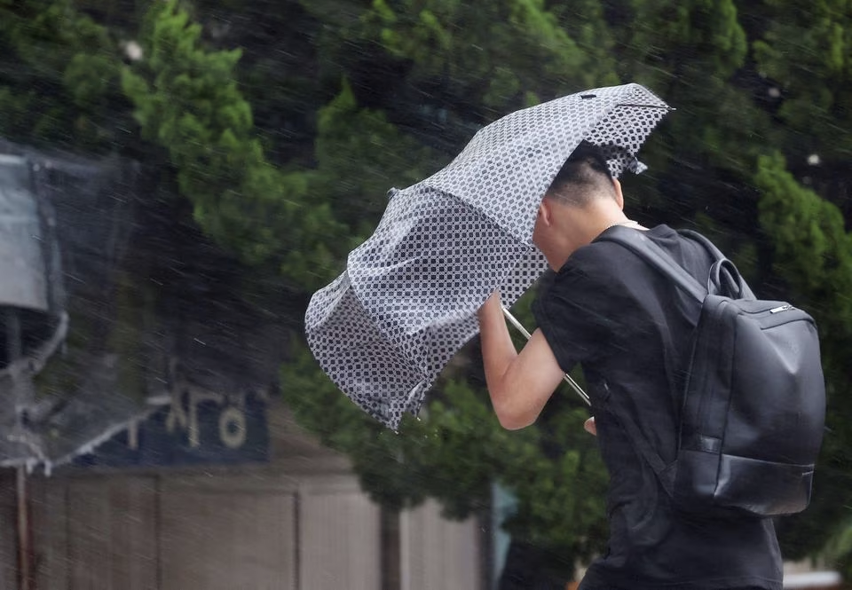 A man makes his way through strong wind caused by typhoon Khanun in Busan, South Korea, August 10, 2023. Yonhap via Reuters