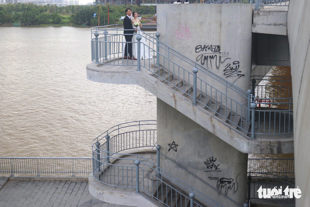 Couples taking wedding photos on the Ba Son Bridge must avoid vandalizing paint.