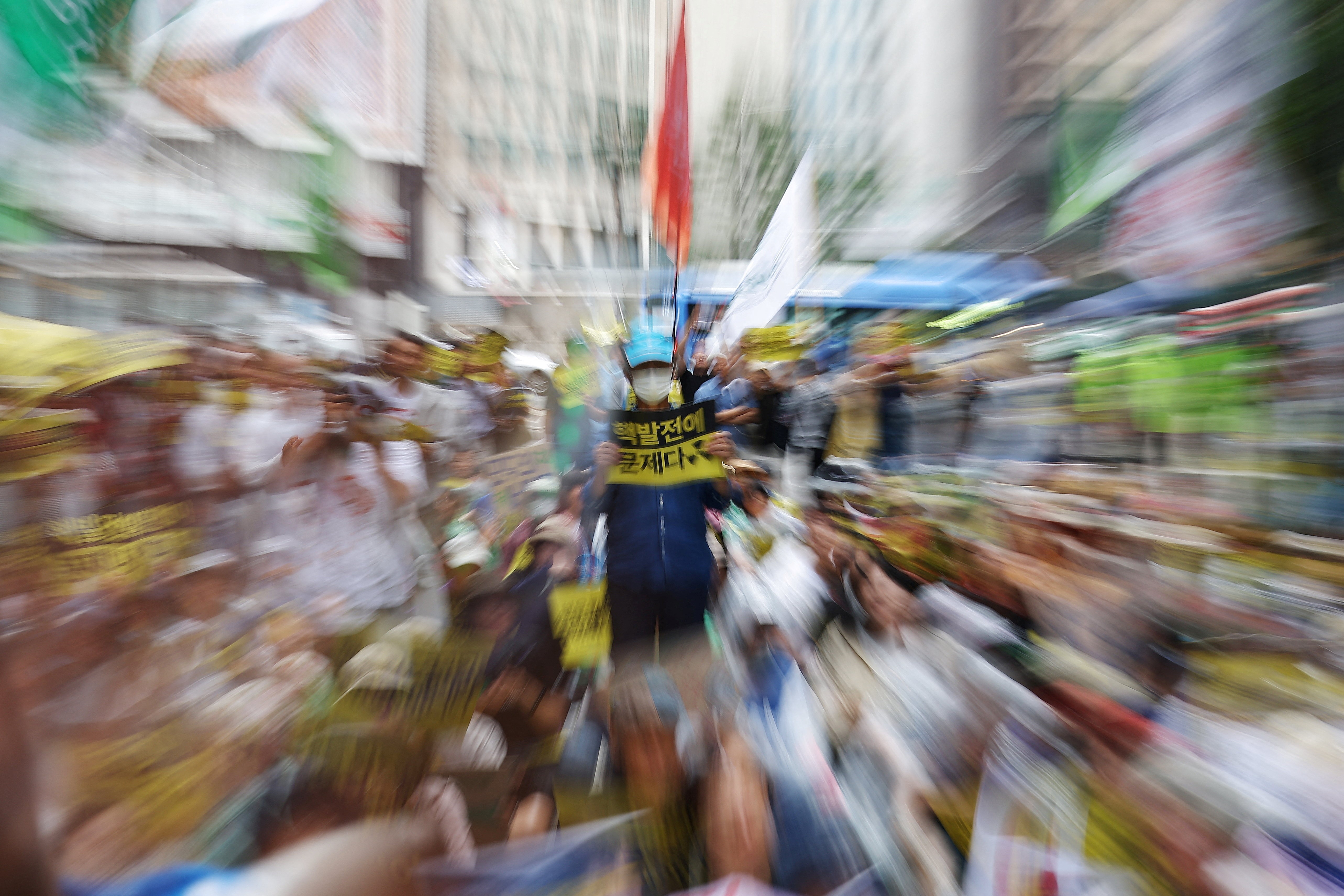 A man holding a sign that reads 'Nuclear power plants is the problem' stands during a protest against Japan's plan to release treated waste water from the Fukushima nuclear power plant into the ocean, in central Seoul, South Korea, August 12, 2023. Photo: Reuters