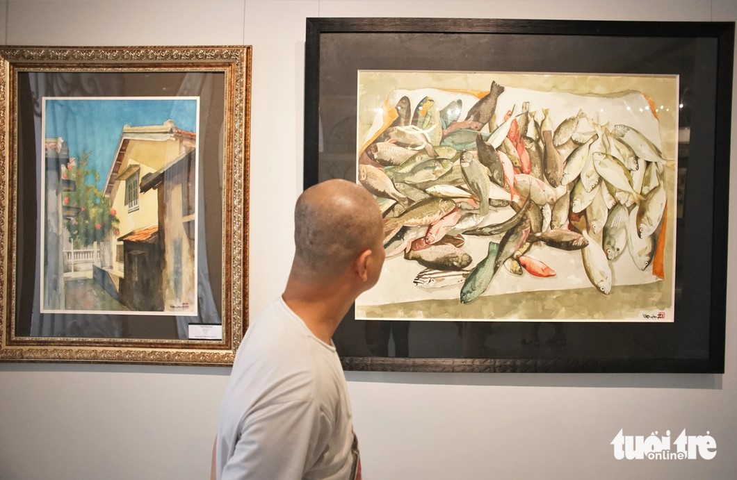 A visitor looks at a painting in Hong Quan’s exhibition. Photo: Huynh Vy / Tuoi Tre