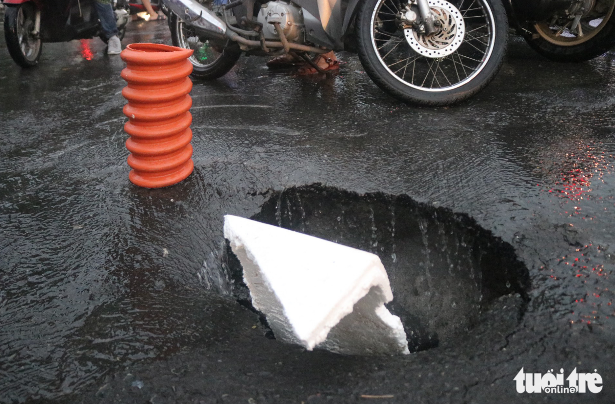 Rainwater flows into a sinkhole on Vo Van Ngan Street in Thu Duc City. Photo: Tien Quoc / Tuoi Tre