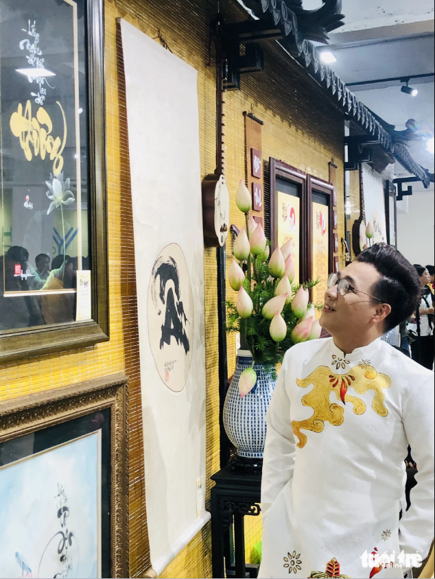 A visitor takes a look at a work by calligrapher Hoa Nghiem, former head of the calligraphy club at the Youth Culture House. Photo: Hoai Phuong / Tuoi Tre