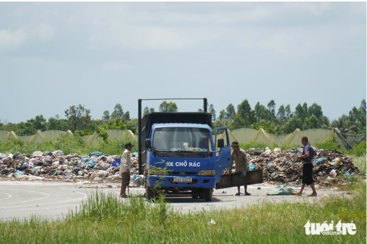 A garbage truck transports trash to the stadium in Ba Tri District